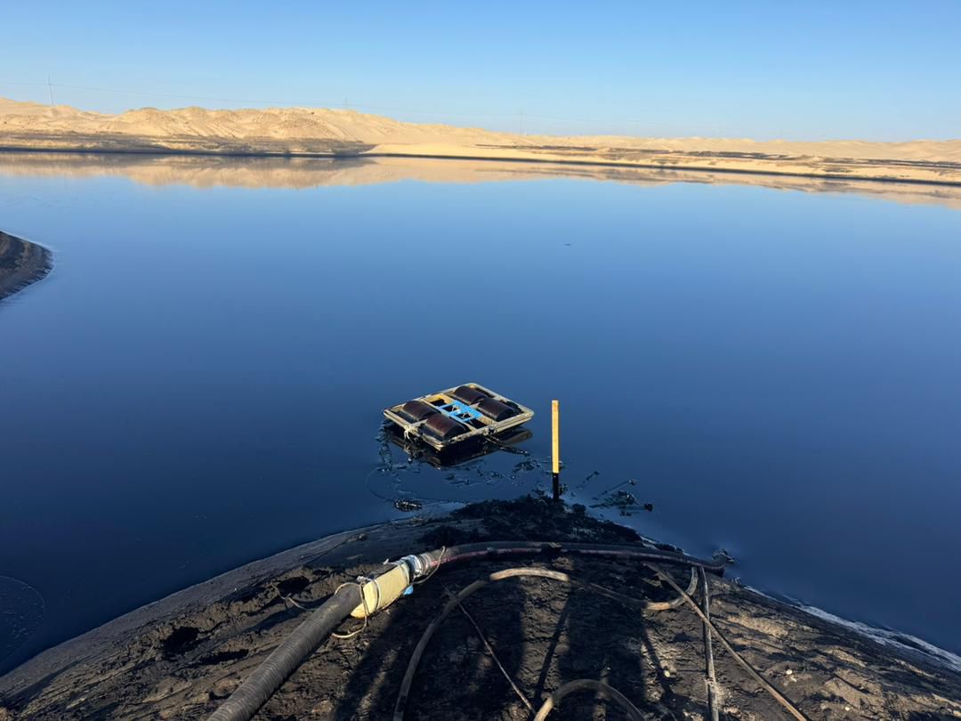 Oil recovery equipment at a produced water pond in a desert oilfield